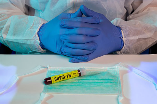 Scientist with surgical gloves and Coronavirus(COVID-19) blood sample test tube on protective face mask COVID-19 Datasets Bring AI Experts, Life Sciences Researchers Together For A Cure 1