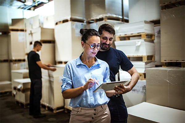 Warehouse supervisor walking and talking with senior manager Retailers Pursuing AI to Help Negotiate Prices, Enhance Operations 1