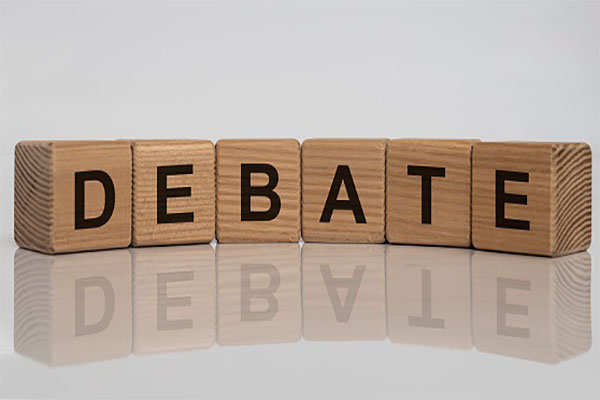 DEBATE word on cube blocks on white grey glossy background with reflection